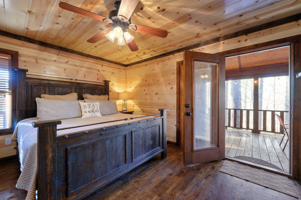 cabin bedroom with views of pine trees 